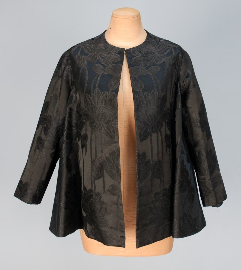 CHRISTIAN DIOR PARIS SILK BROCADE EVENING JACKET, : Cropped black satin with a brocaded pattern of large long stemmed flowers and buds, collarless, flared cut with 3/4 sleeve, lined in black satin. Label stamped "30280". B-40, L-25. Excellent.