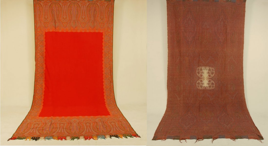 TWO PAISLEY SHAWLS, 19th C.: Both long shawls: One having overall dark red and blue palette with small white lobed center, 126 x 62, (small holes) good. One bright orange palette with open orange field and tabbed border, 128 x 58