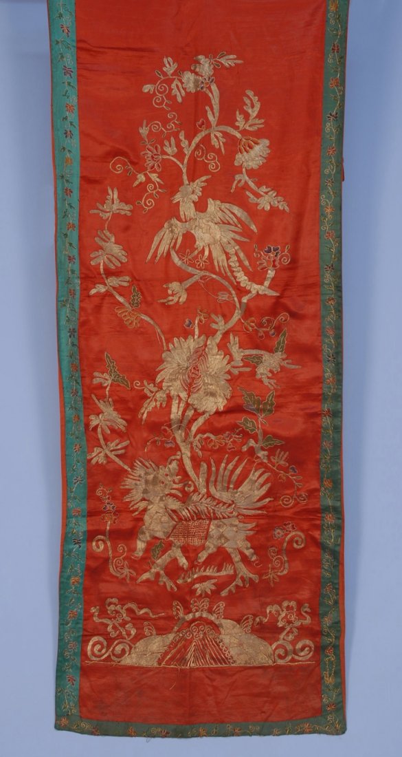 CHINESE SILK and GOLD EMBROIDERY, 20th C.: Narrow panel of red silk embroidery with couched gold metallic threads having qilin, tree and phoenix. 82 x 28. (Slight soiling) very good.