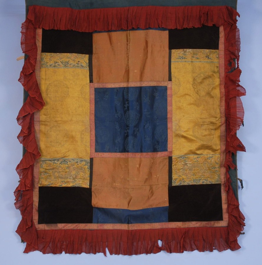TIBETIAN CEILING PANEL, 19th C.: Indigo cotton inset with squares of Chinese brocades, damasks and velvet, with 6 inch red cotton flounce. 63 x 56. (Soiling) very good.