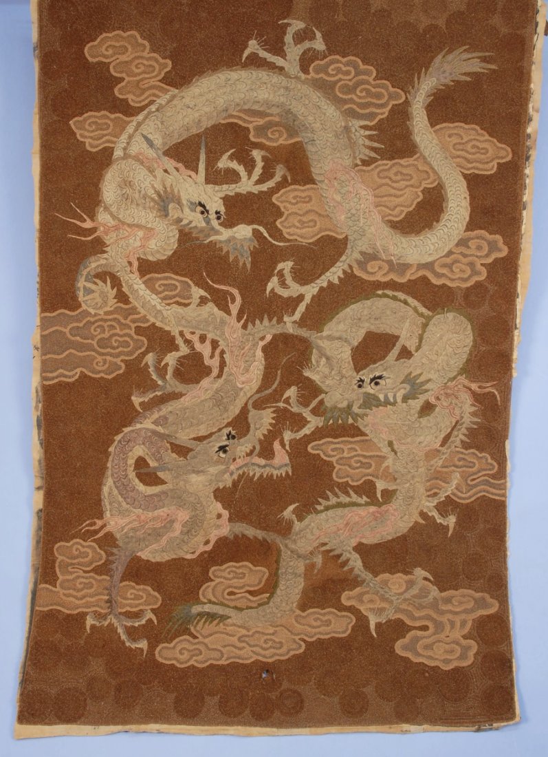 JAPANESE EMBROIDERED DRAGON PANEL, 19th or EARLY 20th C: Couched and embroidered design of three dragons on brown field. 69 x 47. (Small puncture lower center, no fabric loss) very good.