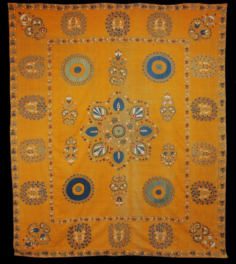UZBEK SUZANI, EARLY 20th C.: Silk on tumeric color cotton, beautifully drawn cartoon with eight petal central medallion densely decorated with red, white, blue and green palmettes, moon disks at the corners all within a border of
