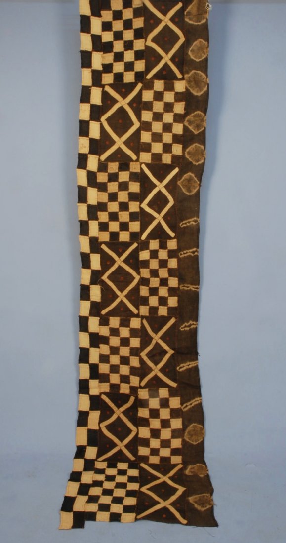 PIECED AFRICAN MUD CLOTH PANEL, 20th C.: Long narrow raffia panel, pieced and appliqued in a pattern of brown and natural blocks and crosses having tiny eyelets embroidered in brick thread with tie dyed border. 24 x 100. Together with a smal