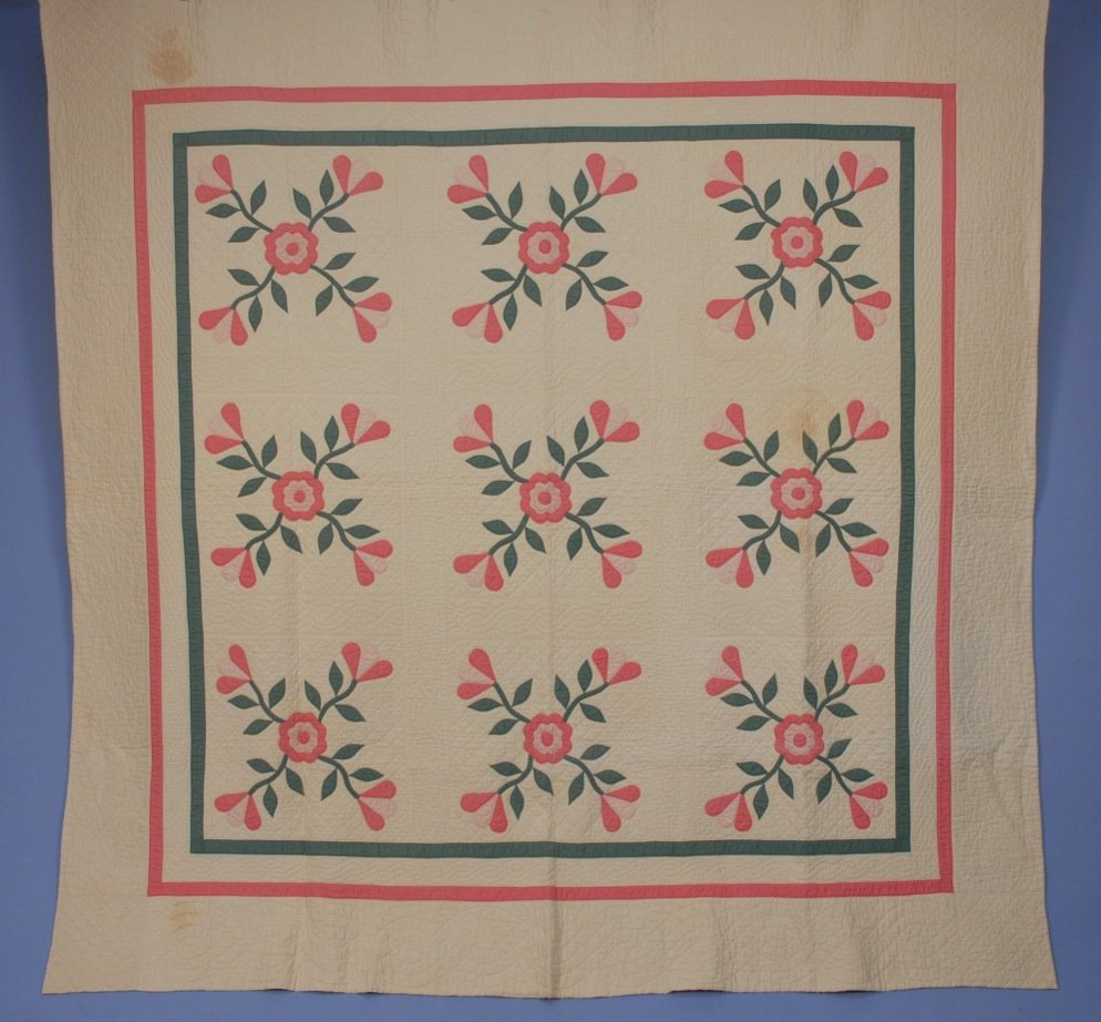PIECED and APPLIQUED QUILT, c. 1930.: Pink and green cotton floral and foliage sprays on heavily quilted cotton white on white lattice, all within pink and green double border. 84 x 82. Excellent.