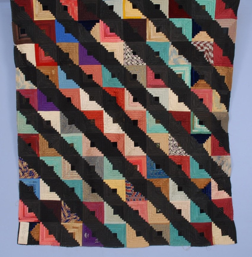 SILK QUILT TOP, 19th C.: Log Cabin or "Straight Furrow" variant, silk dress and men's vest fabrics on early glazed brown cotton backing. Owner/maker's name "Edith J. Mersereau 307 E. Main St." basted to corner. 57 x 53. Excel