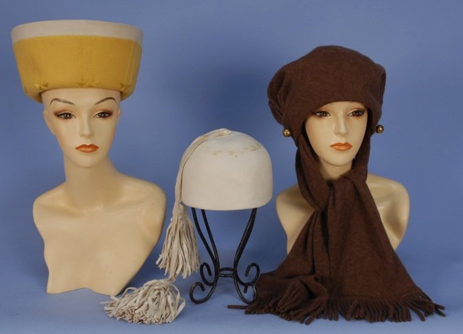 THREE JEAN PATOU HATS, 1965 - 1972.: One yellow and white felt sailor with topstitching. One white leather pillbox with large self tassels. One wool jersey with scarf ties. (White leather few stains at crown) good-excellent. MMA.