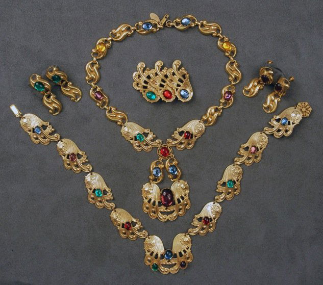 TWO MIRIAM HASKELL CABOCHON SETS.: Necklace and pin with scrolling gilt stampings and colorful cabochons. Similar necklace having two pair matching ear clips. Signed. Necklaces 8 and 11 inches, pin 2 1/4 inches. Excellent.