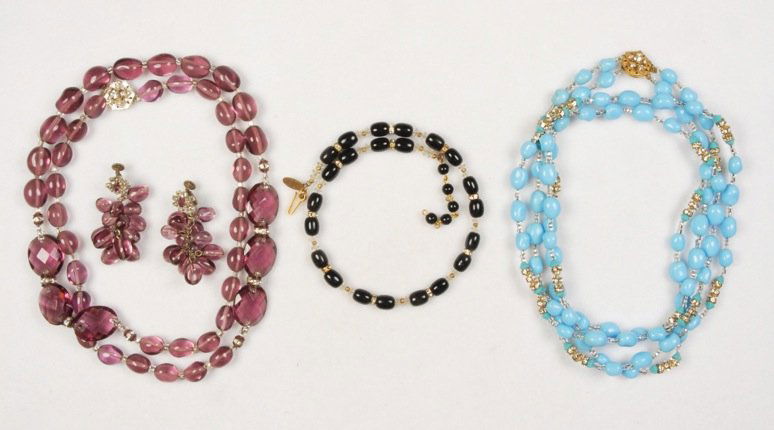 THREE MIRIAM HASKELL NECKLACES.: All glass beads with rhinestone rondelles, one black memory wire choker, one blue double strand, one amethyst having two separations with large faceted beads. Together with a pair of matching amethyst