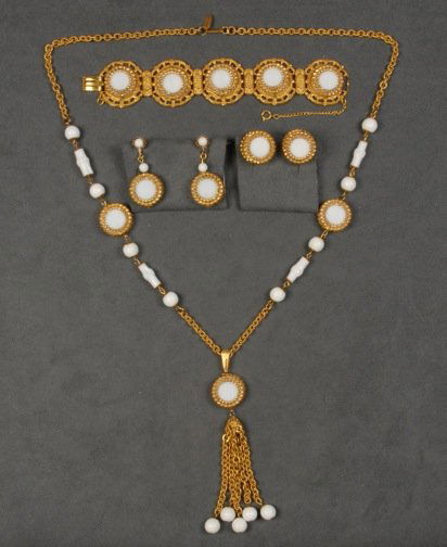 MIRIAM HASKELL DEMI PARURE.: Gilt chain necklace with two separators having round, faux bamboo and disk shaped white glass beads set in filigree, tassel with ball finials, matching hinged bracelet and two pair ear clips. Signed.