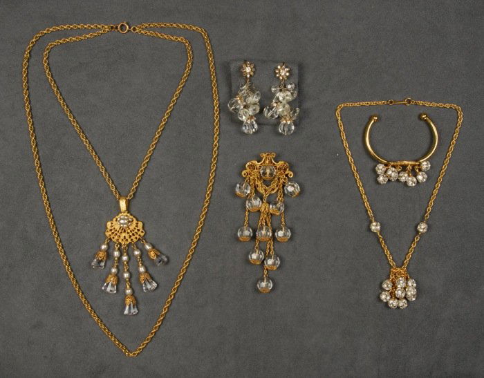 LOT of MIRIAM HASKELL JEWELRY.: Consisting of two gilt chain necklaces, one with rhinestone ball drops and matching bracelet, one double chain with filigree girandole pendant having pearl and faceted glass drops. One filigree pin wi