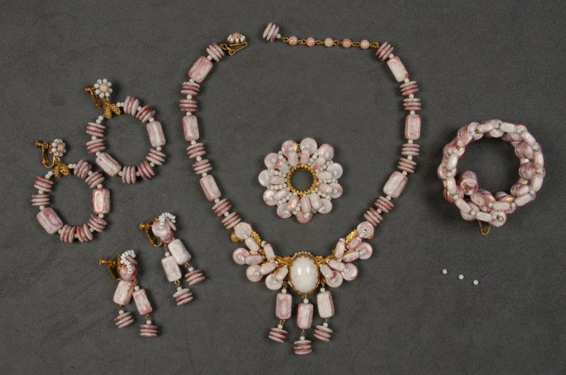MIRIAM HASKELL FIVE PIECE PARURE.: Pink and white beads in various forms, girondole necklace, circle pin, memory wire cuff bracelet and hoop and drop earrings. Signed. Necklace 10 inches. (Minor bead loss to pin) good-excellent.