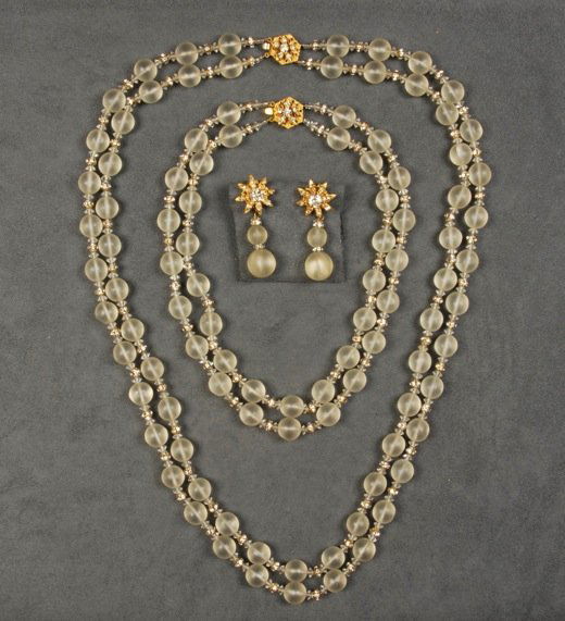THREE PIECES MIRIAM HASKELL FROSTED GLASS JEWELRY.: Two double strand necklaces having rhinestone rondelle and clear faceted spacers, one pair matching ear clips. Signed. Necklaces 8 1/2 and 15 inches. Excellent.