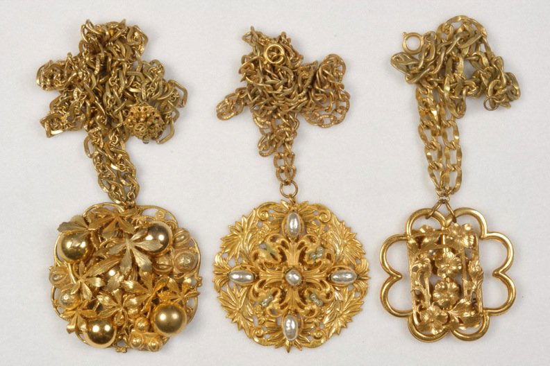 THREE MIRIAM HASKELL MEDALLION NECKLACES.: All having heavy gilt chain and reticulated floral medallions, one with pearls. Signed. 12 - 19 inches. (Some verdigris on pearl medallion) good-excellent.
