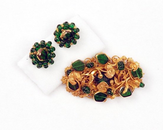 MIRIAM HASKELL PIN and EARRING SET.: Oval pin of gilt lily pad finding set with flattened glass and molded glass beads with matching ear clips. Signed. Pin 3 x 1 1/2 inches. Excellent.