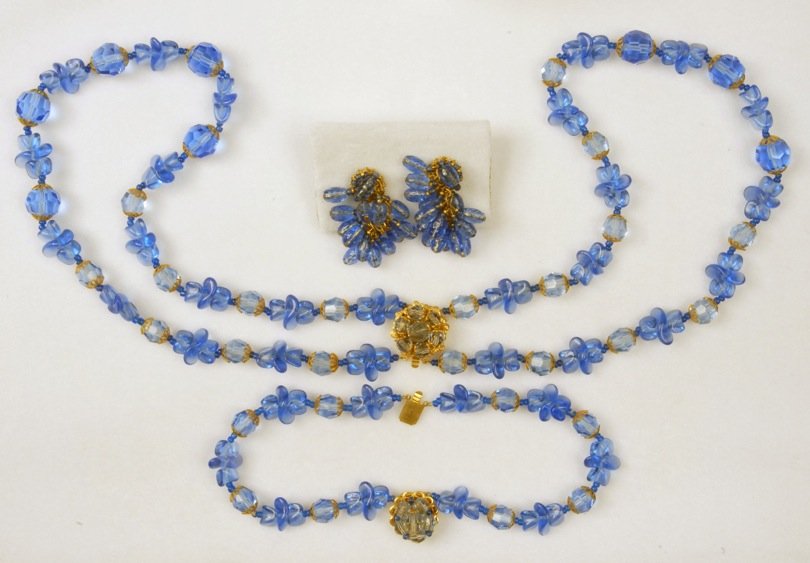 THREE PIECES MIRIAM HASKELL ART GLASS JEWELRY.: Double strand necklace of sapphire blue molded and faceted beads with gilt filigree caps, matching double strand bracelet. Ear clips having cluster of oval sapphire beads. Signed. Necklace 10 inches.