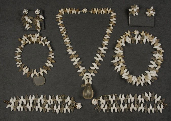 MIRIAM HASKELL SHELL PARURE.: All having molded white and frosted glass beads, three necklaces, two having plastic fruit pendant, pair of matching double strand bracelets and two pair ear clips. Signed. Longest necklace 15 inches.