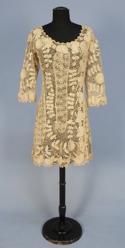 IRISH CROCHET DRESS, 1920's.: Short length with elbow length sleeve having large scale floral pattern with some raised flower heads, side closure. B-38, W-28, H-38, L-37. (Few small light brown spots, few broken brides) very good.