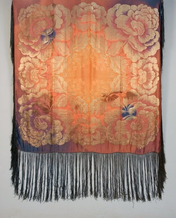 ART DECO OMBREED SILK and GOLD LAME SHAWL, 1920's.: Large square having gold metallic oversized floral in salmon, pink, purple and blue with long blue silk fringe. 61 x 63 with 18 inch fringe. (Scattered tiny holes, small oxidized spot) very good.