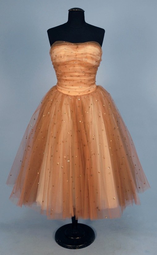 HOWARD GREER STRAPLESS TULLE PARTY DRESS, 1950's.: Nude tulle over white, studded with rhinestones set over silvered sequins, boned and ruched bodice having curved waistline, very full layered skirt over narrow silk crepe underskirt, back zipper. Labe