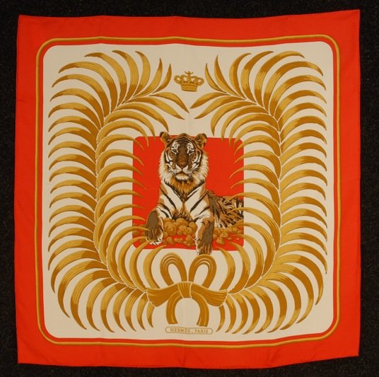 DEADSTOCK HERMES PRINTED SILK "TIGRE ROYAL" SCARF, 1977: Central tiger flanked by palm fronds on white ground with red border, artist Christiane Vauzelles. Neiman Marcus tag attached. 35 x 35. Excellent.