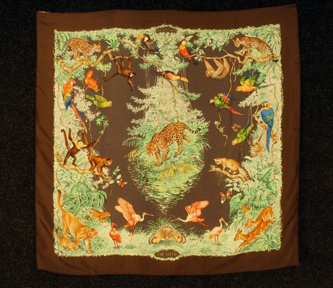 HERMES PRINTED SILK "EQUATEUR" SCARF, 1984 DESIGN.: Rain forest animals and birds within trees on brown ground, artist Robert Dallet. 35 x 35. Excellent.