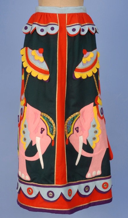 MALCOLM STARR APPLIQUED CIRCUS SKIRT, 1970's.: Green wool appliqued with elephant and rider in colorful felt, metallic gold and printed cotton. Labeled. W-25, L-39. (Tiny spot on back) very good.
