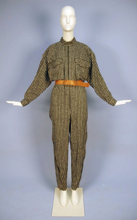 ISSEY MIYAKE ZIPPERED COTTON JUMPSUIT, 1980'S.: Black and heathered grey stripe having stand collar, zip front with neck insert, bellows breast pockets, side zipper from above the knee to ankle opening from tapered to wide leg. Labeled. Size M. Tog