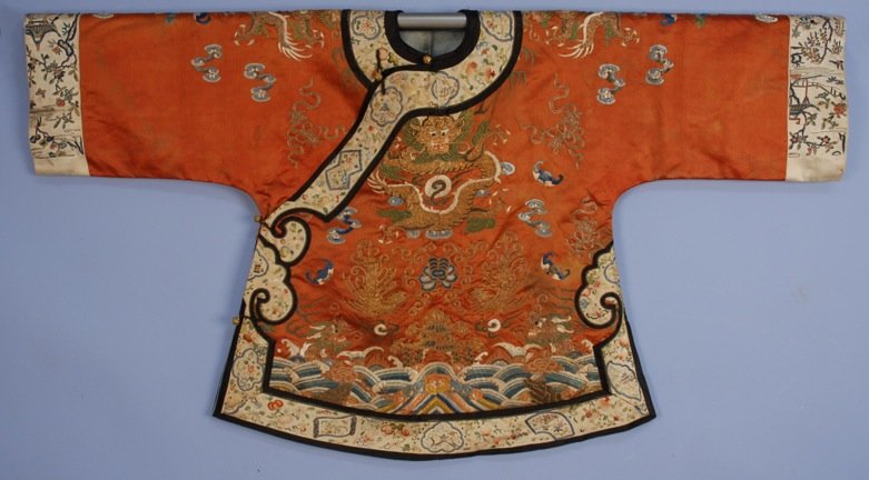 CHINESE SILK EMBROIDERED SHORT ROBE, 19th C.: Cinnamon satin with couched metallic gold and green, blue and white satin stitch and Peking knot silk embroidery, decorated with dragons, clouds, bats, etc., over pagoda and li shui border, trimmed wi