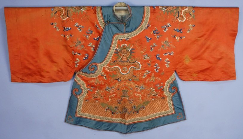 CHINESE SILK EMBROIDERED SHORT ROBE, 19th C.: Cinnamon satin having couched metallic gold threads with satin stitch and Peking knot in blue, green and white silk, four forward facing dragons over pagoda with phoenix birds, dogs and dragons, trimm