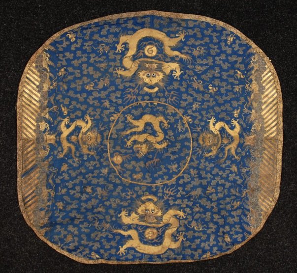 CHINESE CUSHION COVER, 19th - 20th C.: Blue lobed rectangular silk with five dragons executed in couched gold thread, field decorated with couched cloud bands and li shui border on two sides, possibly a robe at one time. 38 x 38. (Soiled a