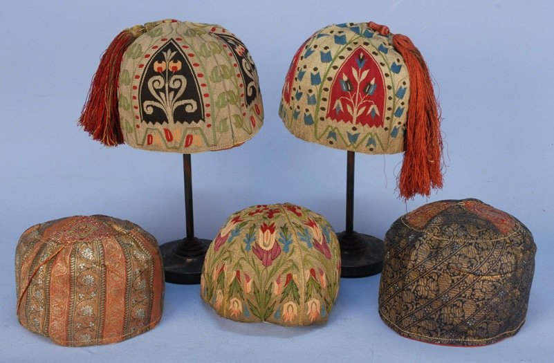 THREE MIDDLE EASTERN SKULLCAPS, 19th C.: All tapestry twill with multicolored floral pattern on metallic ground, two having silk tassel. Together with two Iranian metallic brocade skullcaps, 19th C. Excellent. MMA.