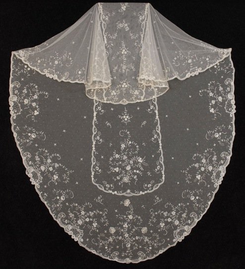 BRUSSELS LACE on NET VEIL, 1950's.: Oversized oval of dotted white tulle with appliqued vining floral decoration having central panel all within scrolling border. 68 x 118. Excellent.