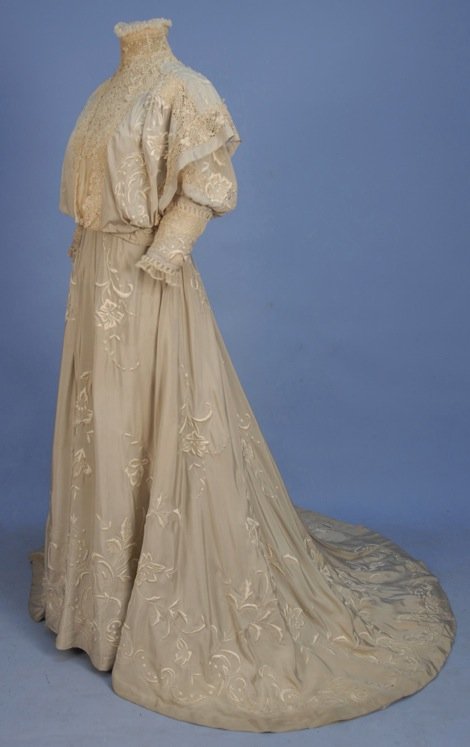 TRAINED SILK HIGH NECK GOWN with EMBROIDERY, 1890's.: Grey 2-piece with white floral in satin stitch and French knots, pigeon-breasted bodice with Irish crochet neck insert and trim bands to shoulder over-panels, upper puffed sleeve and fitted elbow band