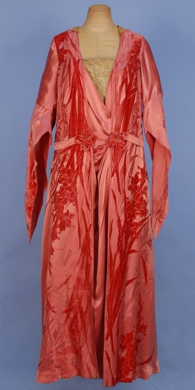 SATIN DINNER DRESS, c. 1919.: Rose pink satin and cut velvet having long dagged sleeve, cream lace collar and neck insert, self belt threaded through folded back panels, lined in crepe-de-chine. B-42, W-40, L-57. (Lining fragile, 