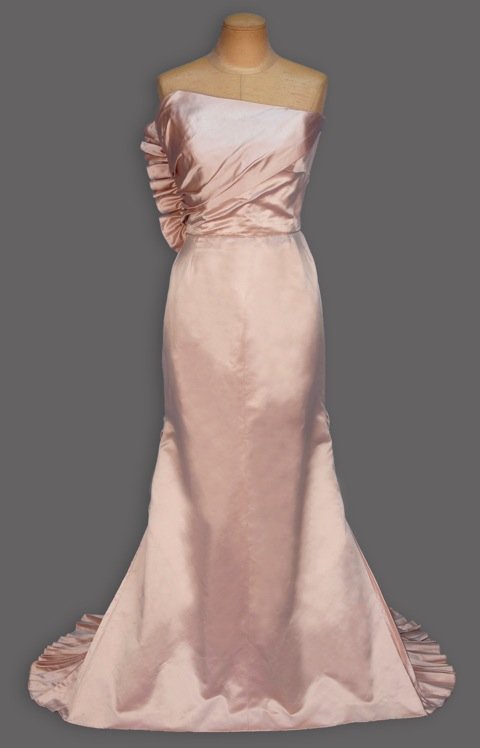ADRIAN STRAPLESS EVENING GOWN and JACKET, 1940's.: Dusty pink silk having asymmetrical semi boned bodice with diagonal drape ruched into side seam, trained skirt with three pleated gores and lower back swag. Matching jacket with long sleeve pleated at