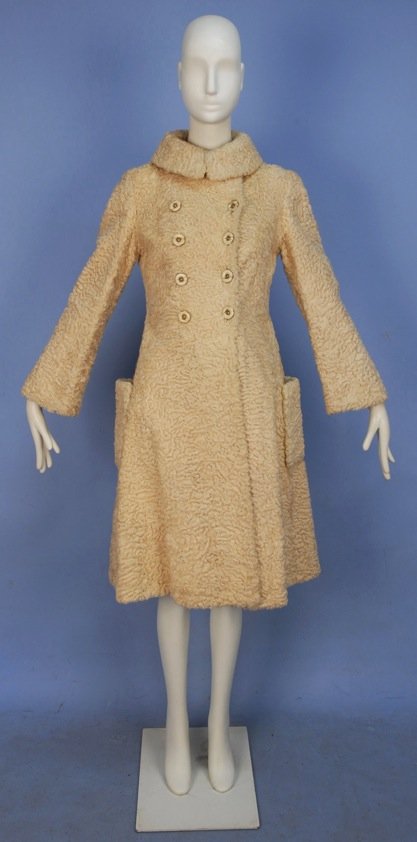 GALANOS CURLY LAMB COAT, 1960's.: Double breasted cream fur with fold over collar, side patch pockets, flared skirt and slight bell sleeve, cream and vaseline colored buttons. Labeled. B-36, W-34, L-42. (One pocket partially unstitche