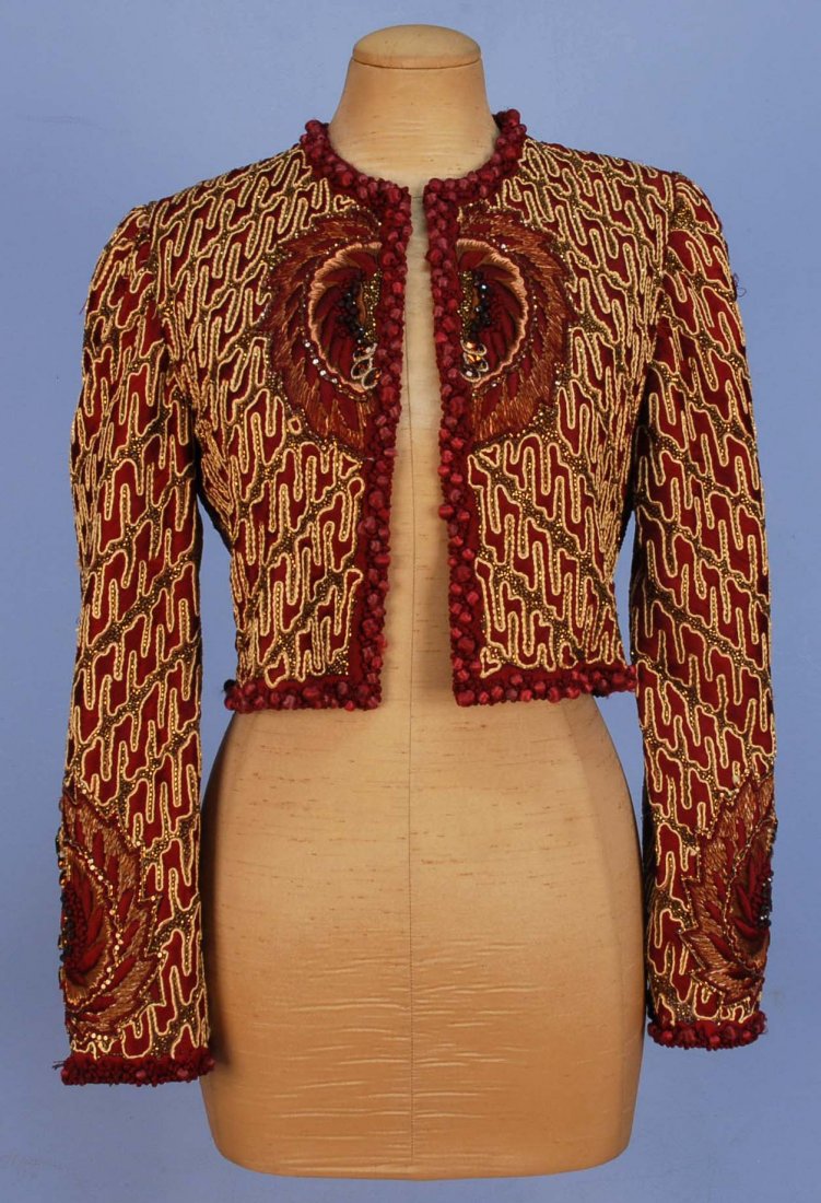 UNLABELED MARY McFADDEN BEADED EVENING JACKET, 1970's.: Collarless cropped style decorated allover in bronze bugle beads with couched ivory and cranberry satin stitch embroidery, jeweled medallion on center front, back and lower sleeves, cranberry silk bal