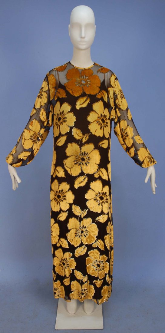 GALANOS VOIDED VELVET EVENING DRESS, 1970's.: Long sleeve gold silk velvet cut to brown chiffon in a pattern of large flowers outlined in gold lurex threads, jewel neck, gathered cuff, self button and loop closure over a layered under-dress of br