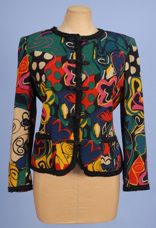 EMANUEL UNGARO PRINTED WOOL JACKET, 1980's.: Colorful abstract design on black crepe, with black wool trim, patch pockets and silk frogs over snap closure. Parallele label. Size 8. (Tiny hole) very good.