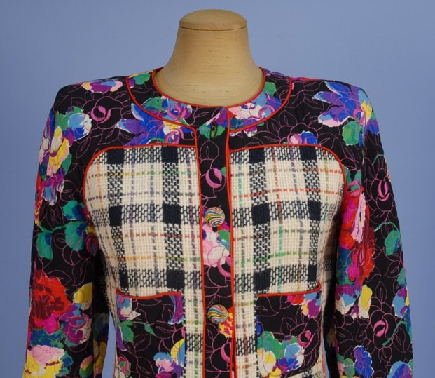 TWO EMANUEL UNGARO SKIRT SUITS, 1980's.: One olive wool plaid flecked with metallic thread and colorful yarns, having four patch pockets and gilt buttons with resin center, size 8. One with jacket in black and white plaid pieced with floral 