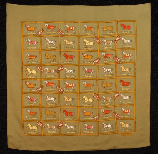 HERMES PRINTED SILK SCARF.: Olive twill depicting thoroughbreds within a lattice of equestrian hardware. Marked "Hermes Paris". 31 x 31. Excellent.