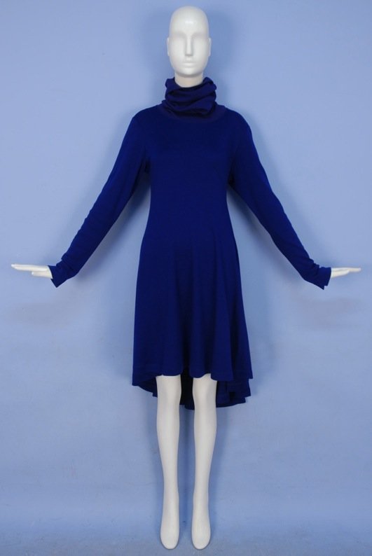 ISSEY MIYAKE WOOL KNIT DAY DRESS.: Blueberry long sleeve with extra long ribbed turtleneck having curving diagonal front and back seam, notched cuff and circle skirt dipping to mid calf at back. Labeled. Marked size small. Excellent.