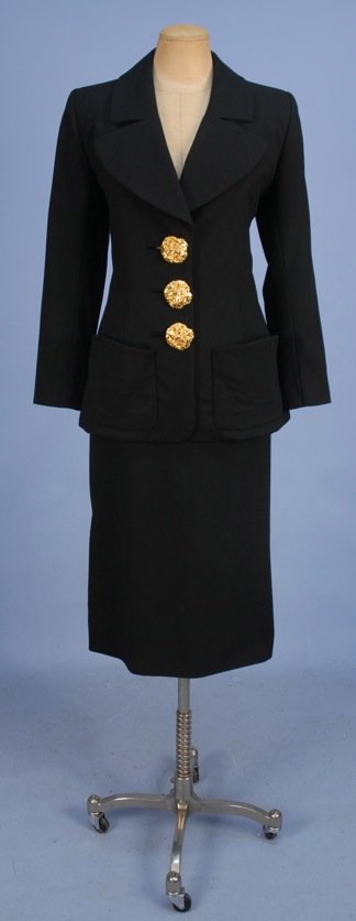 YVES SAINT LAURENT RIVE GAUCHE SKIRT SUIT, LATE 20th C.: Black wool crepe having long jacket with wide curved lapel, patch pockets with curved top, large gilt "crumpled" buttons, matching long pencil skirt with angled pockets. Labeled. Size 38. Excellent.
