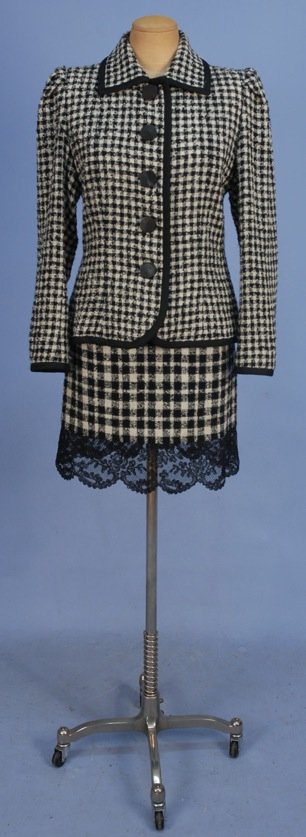 YVES SAINT LAURENT RIVE GAUCHE PLAID SKIRT SUIT, LATE: Black and white looped weave jacket having square collar, braided trim and spiral incised composition buttons. Mini skirt in larger scale plaid with wide scalloped black lace hem band. Labeled. Size 4