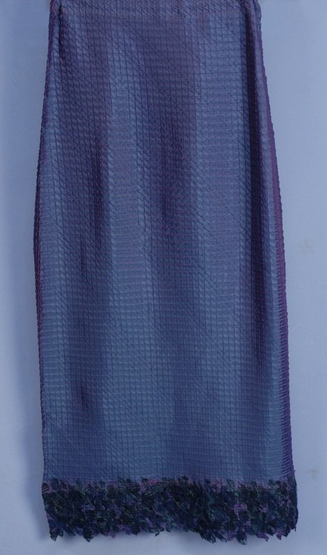 ISSEY MIYAKE ORIGAMI SKIRT.: Changeable poly satin crimped in a pattern of triangles with applied hem band of printed chiffon with embroidery, elastic waistband. Labeled. Marked size 3. Excellent.