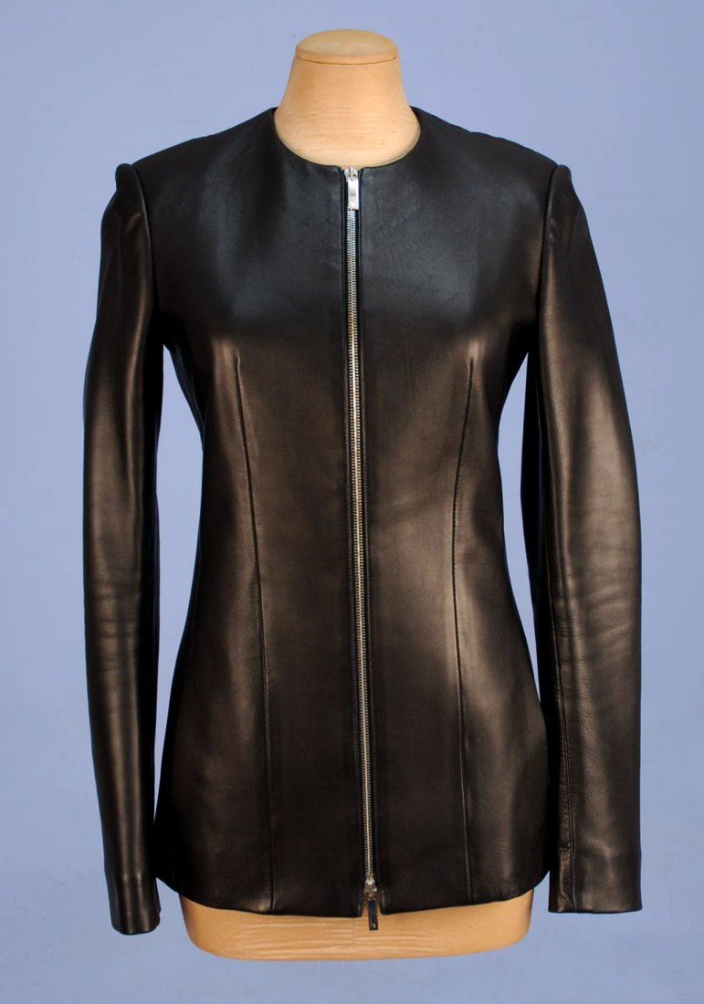 THE ROW LEATHER JACKET.: Collarless fitted black lambskin. Hip length with front zipper and side seam pockets. Labeled. B-34, W-30, Sh-15, Slv-25, L-28. Excellent.