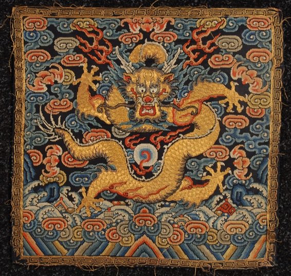 CHINESE EMBROIDERED SUMMER RANK BADGE, 19th C.: Counted stitches on silk gauze having forward facing five claw dragon in couched gold metallic threads. 11 3/4 x 12 1/4. (Losses to gold thread border) very good.