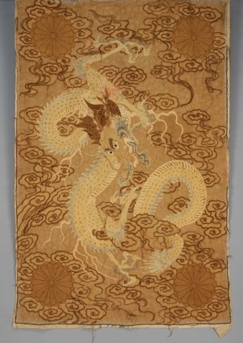 JAPANESE EMBROIDERED TAPESTRY, EARLY 20th C.: Dragon with cloud bands in couched silk and metallic threads with chrysanthemum mons in each corner. 70 x 46. (Loose couching particularly in clouds, red stain) fair.