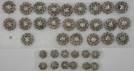 SET of BRITISH PASTE COAT and WAISTCOAT BUTTONS, LATE: Pierced silvered metal with omega shaft having jeweled flower head design: 24 coat buttons, each 1 1/8 in diameter, 12 waistcoat buttons, each 5/8 in diameter. (One large button missing two stones, fi