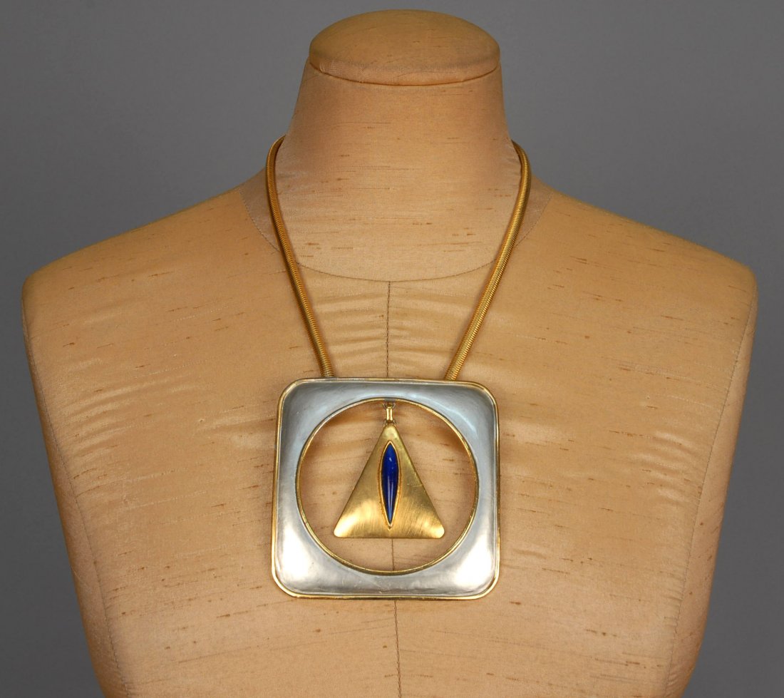 PIERRE CARDIN MOD PENDANT NECKLACE, c. 1970.: Large square goldtone pendant having triangular drop within a circular cutout, blue and silver enamel, gold rope chain. Signed. Pendant 3 1/2 x 3 1/2, overall L-12. (Minor gold loss to rim of pendant)